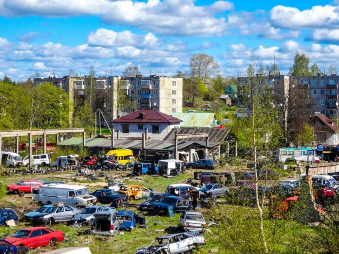 Junkyard with old cars and apartment buildings