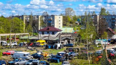 Junkyard with old cars and apartment buildings