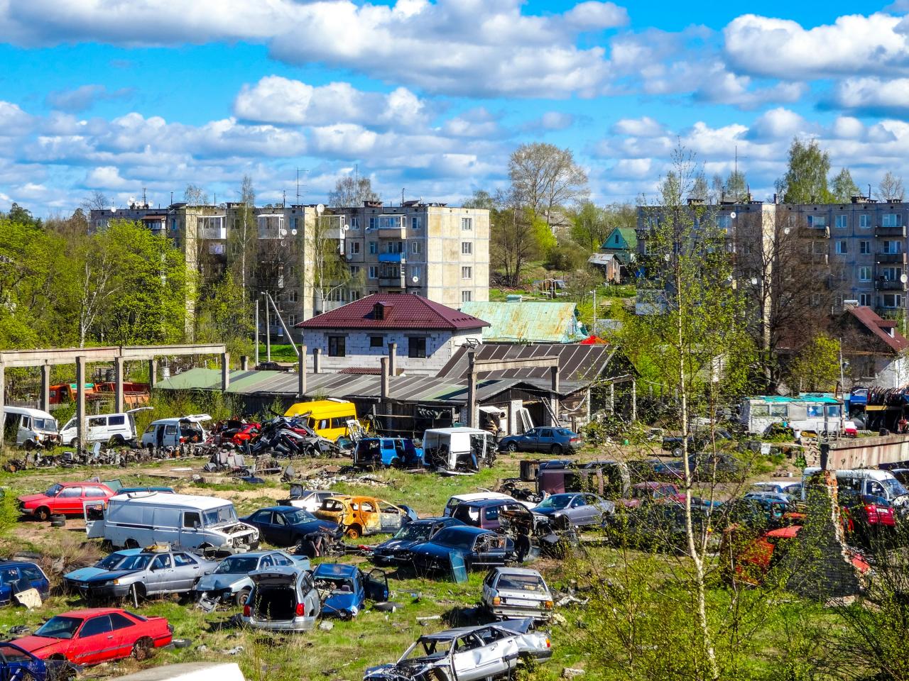 Junkyard with old cars and apartment buildings