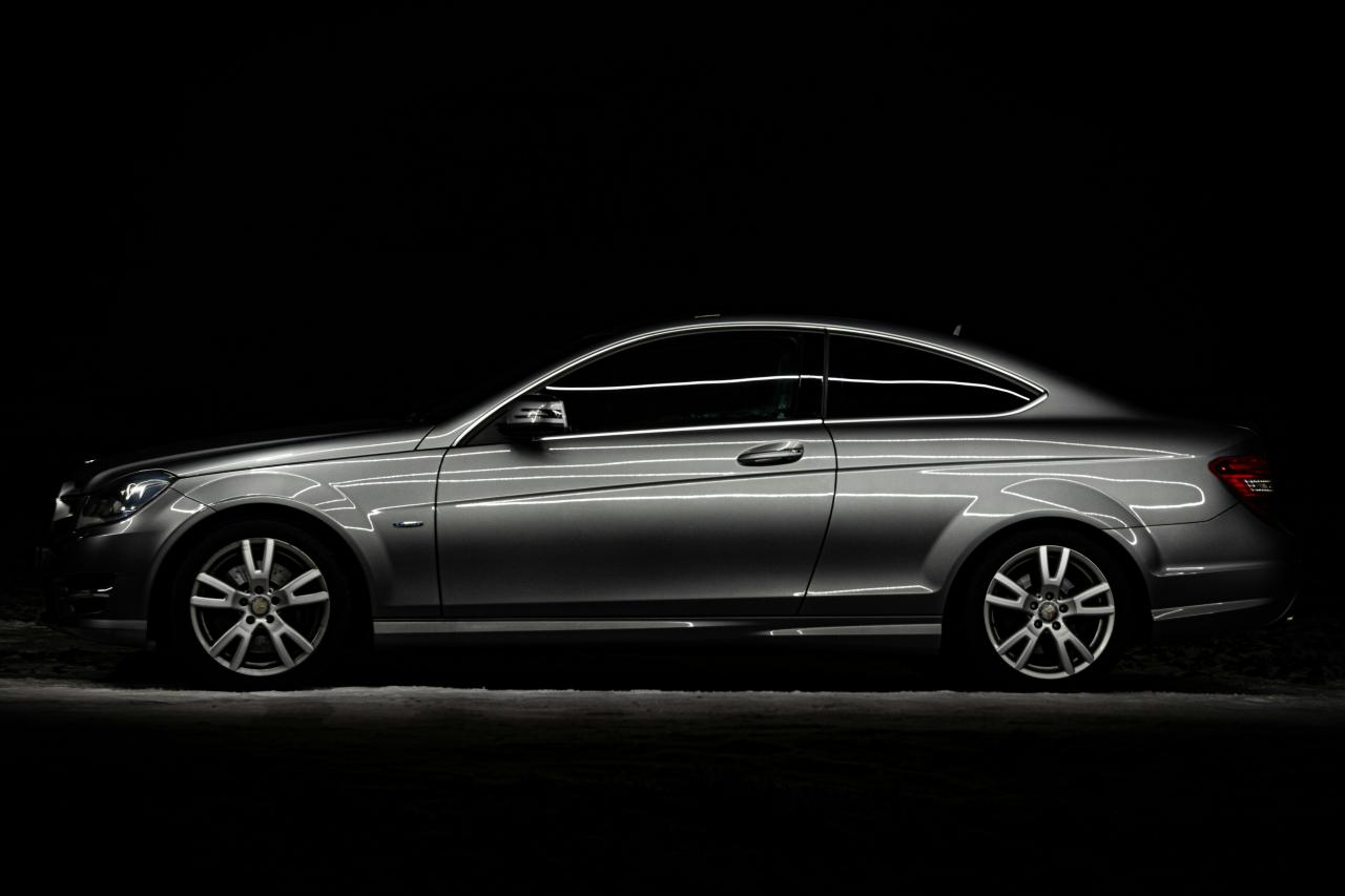 Sebuah mobil perak diparkir di tempat gelap